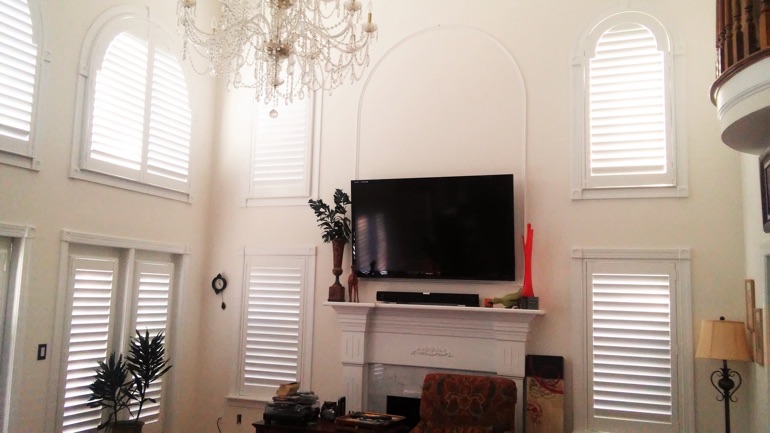 Las Vegas great room with wall-mounted TV and arched windows.